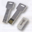 Drei metallene USB-Sticks in Schlüsselform: Einer in Plastikhülle, einer mit sichtbaren Kontakten, einer umgedreht - Vorder- und Rückseite sichtbar. Wertica Shop