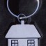 Metall-Schlüsselanhänger in Hausform mit Tür und zwei Fenstern, am runden Ring, vor dunklem Hintergrund. Wertica Shop
