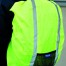 Eine Person trägt draußen die leuchtend gelbe YOKO Sicherheits-Rucksack-Hülle mit silbernen Reflexstreifen, Netztasche und Label. Wertica Shop