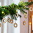 Ein Tannenzweig mit Lichterkette und Holzsternen, im Hintergrund Kerzenschein - stimmungsvolles Setting für das Geschenkpapier "Zimmerer". Wertica Shop