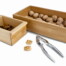 Das Nussknacker-Set "Knack-Zack" enthält 2 Holzkästchen mit Walnüssen, Walnusshälften, Nussknacker und Walnussstücken auf weißem Untergrund. Wertica Shop