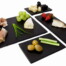 Verschiedene Häppchen auf 4 Schieferplatten: Prosciuttogrissini, Käse, Trauben, Oliven, Gurke, Erdbeeren und Fisch - stilvoll angerichtet. Wertica Shop